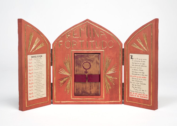 Photo of open altar standing on table - inlaid paper on left and right inside doors - nestled book with Venus symbol is held in place by a burgundy ribbon