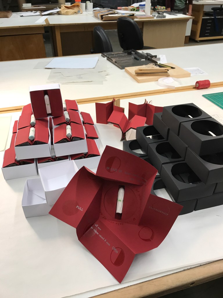 Photo of an open gift box in front of others in the process of assembly