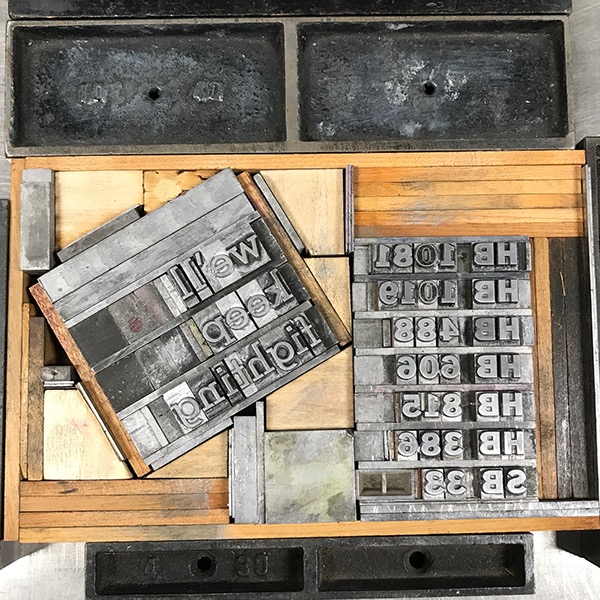 Photo of letterpress bed with "we'll keep fighting" and list of law numbers, with letterpress furniture